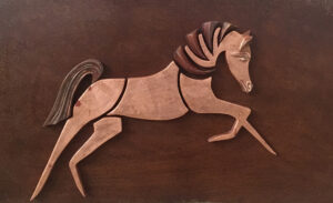 Puledro rampante. Puzzle calamitato: gesso a oro, foglia di rame, lastra di ferro ossidata. Dim. 40 x 60 cm.
