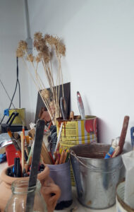 Contenitori con pennelli, matite e altro su tavolo del laboratorio